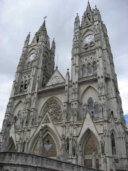 The front façade of the Basilica of the National Vow (Basílica del Voto Nacional) in Quito, Ecuador. Construction began in 1892, and the formal consecration occurred in 1988. The basilica remains technically unfinished, since, according to local legend, its completion would signal the end of the world. The edifice is the largest Neo-Gothic basilica in the Americas.